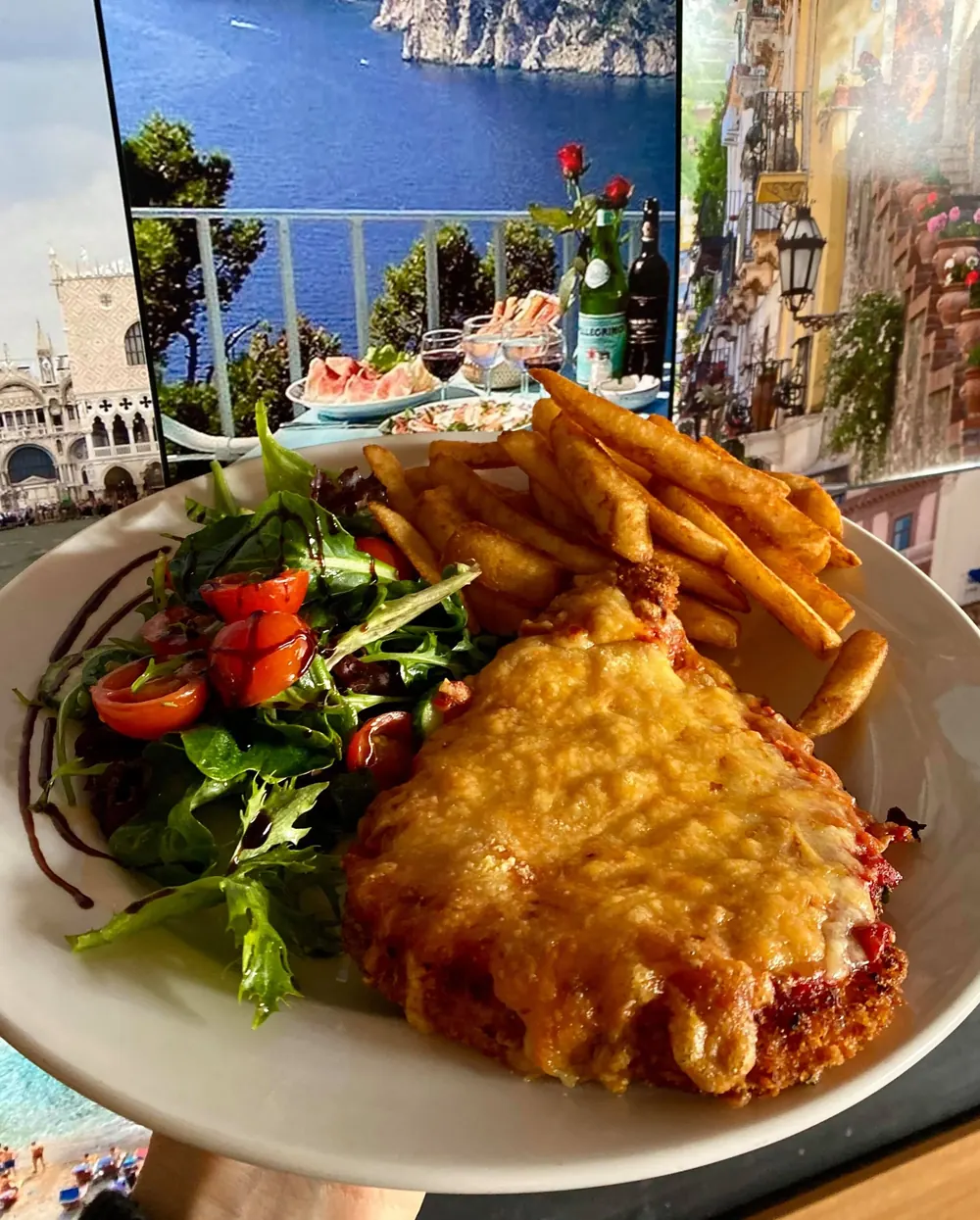 Chicken parmigiano in front of the Positano mural